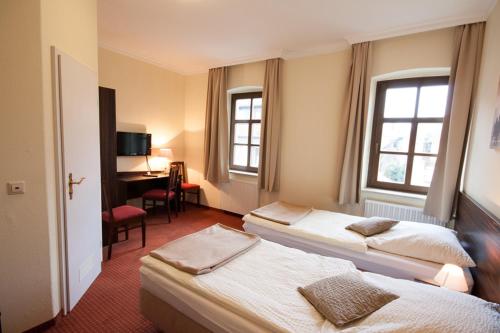 诺斯罗驰林德餐厅及酒店 的酒店客房设有三张床和一张书桌