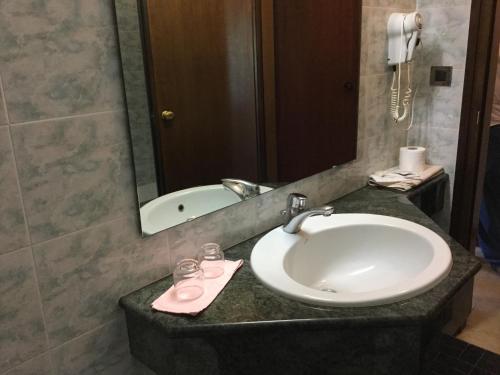 蒙特格罗托泰梅Hotel Terme Vulcania的浴室配有盥洗盆、镜子和浴缸