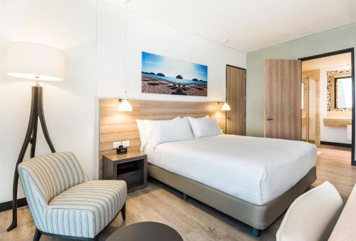 巴兰基亚巴兰基亚布埃纳维斯塔智选假日酒店的配有一张床和一把椅子的酒店客房
