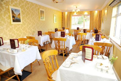 基拉尼阿什维尔旅馆的用餐室配有白色的桌子和黄色的椅子