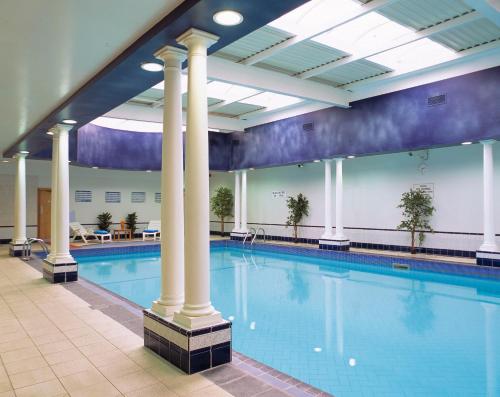特拉利Brandon Hotel Conference & Leisure Centre的一座建筑物内一座带柱子的游泳池