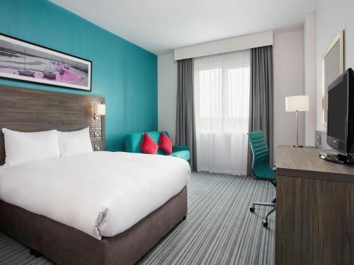 南安普敦Leonardo Hotel Southampton的酒店客房设有一张大床和一台电视。