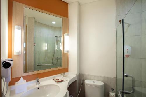 雅加达雅加达哈莫尼宜必思酒店的浴室配有卫生间、盥洗盆和淋浴。