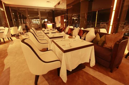 北干巴鲁北干巴鲁皇家安索诺夫酒店的一间设有白色桌子和沙发的用餐室