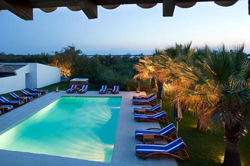 圣马迪拉莫曼吉欧矿泥温泉酒店的一组躺椅和一个游泳池