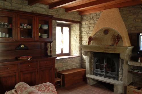 Pianelleto农场山度假屋的一间客厅,客厅内配有石头壁炉。