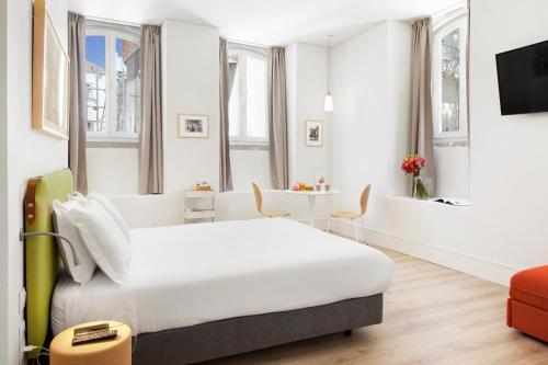 里斯本埃森萨尔比卡里斯本服务式公寓的酒店客房设有一张大床和一张桌子。