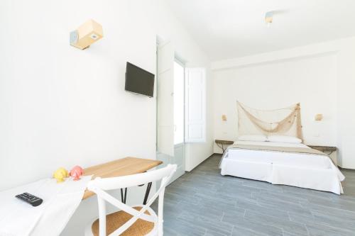 普尔萨诺唐格拉姆酒店的白色卧室配有床和书桌