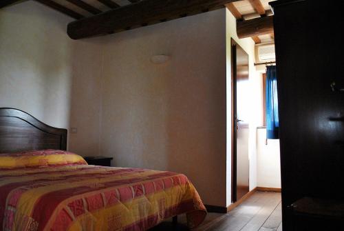 Monte San PietrangeliAgriturismo Oasi Belvedere的一间卧室配有一张带彩色毯子的床