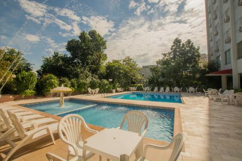 伊瓜苏San Juan Tour的游泳池配有桌椅和桌椅