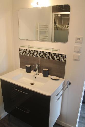 Saint-Gervais en-Belin农场住宿加早餐旅馆的一间带水槽和镜子的浴室
