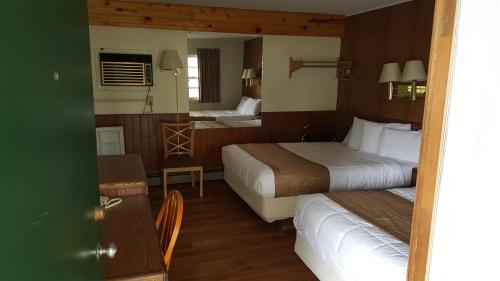 底特律莱克斯Budget Host Inn的酒店客房设有两张床和一张桌子。