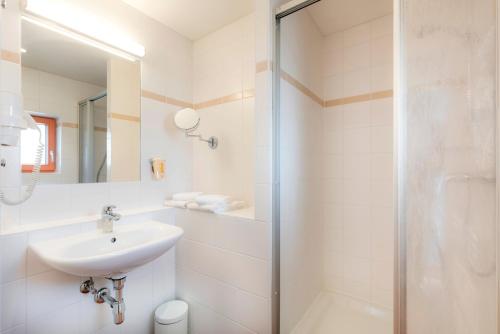 滨湖施图本贝格斯图本堡湖JUFA酒店的白色的浴室设有水槽和淋浴。