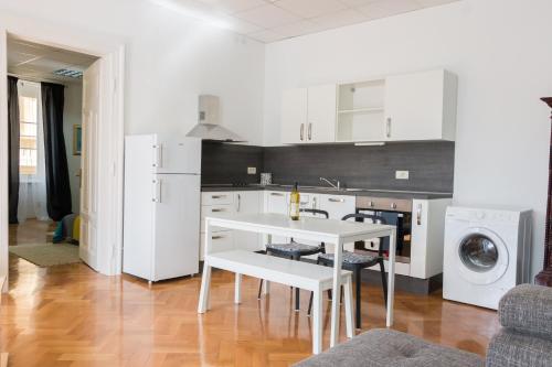 奥帕提亚Sunny Apartment Anamaria Opatija的厨房配有白色橱柜和白色桌子