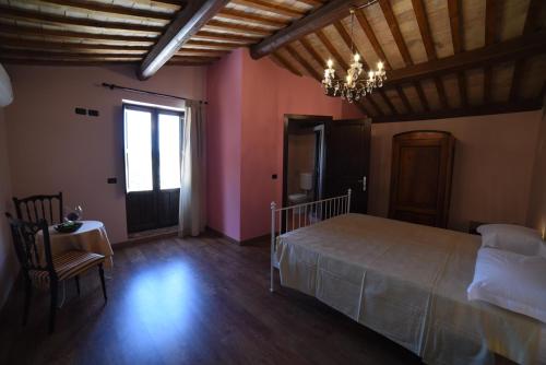 瓦克瑞Agriturismo " La Valle degli Ulivi"的一间卧室配有一张床、一张桌子和一个吊灯。