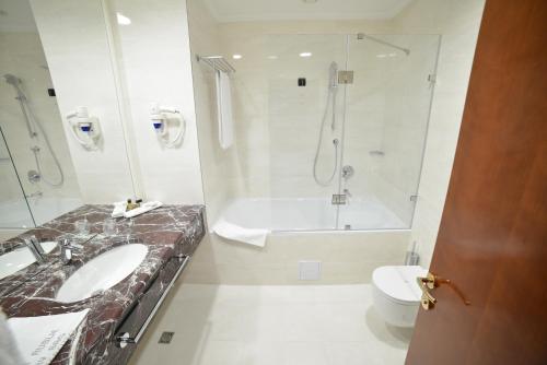 图兹拉梅拉尼酒店的一间带两个盥洗盆、浴缸和卫生间的浴室