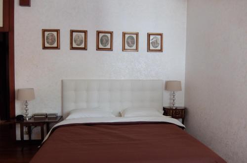 卡奥莱La Casa di Enrico的卧室配有一张大床,墙上挂有三幅画