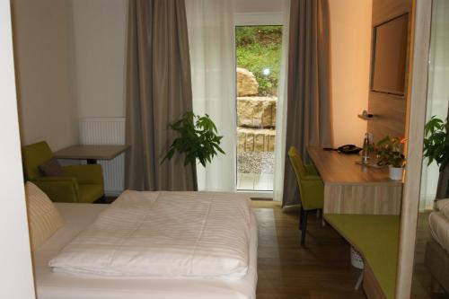 洛尔希姆肯西餐厅酒店的配有一张床、一张书桌和一扇窗户的酒店客房
