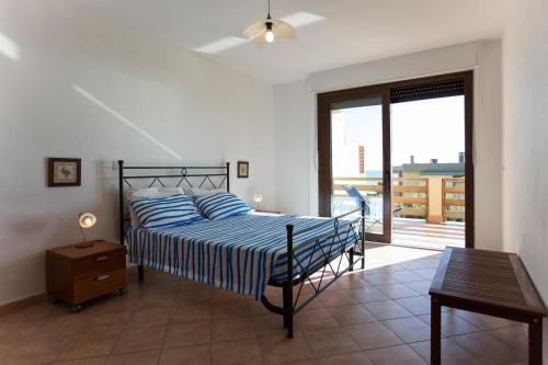 阿尔盖罗Elena House的一间卧室配有一张床、一张桌子和一个窗户。