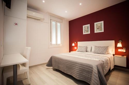 马德里Pensión Corbero的一间卧室设有一张床和红色的墙壁