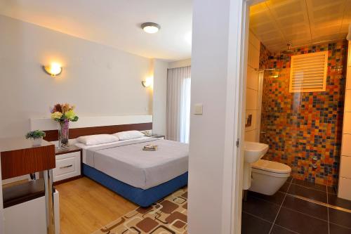 切什梅卡利斯酒店的一间卧室配有一张床,浴室设有卫生间