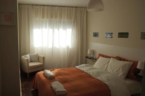 马托西纽什Porto 2 Bedroom Beach Apartment的卧室配有床、椅子和窗户。