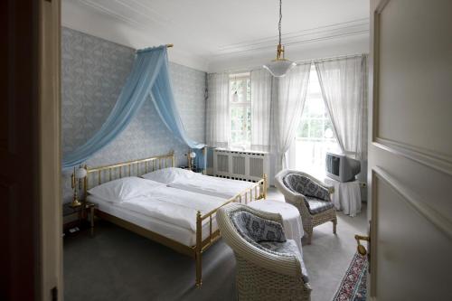 海尔布隆公园别墅酒店的一间卧室配有一张床和两把椅子
