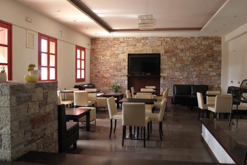 LivadiAposperides Hotel的一间带桌椅的餐厅以及砖墙