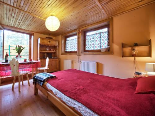 扎科帕内奥姆索卡旅馆的一间卧室配有一张带红色毯子的大床