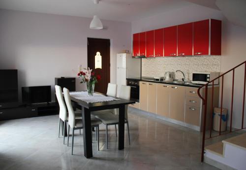 DrymonSun Gazing Villas的厨房配有桌椅和红色橱柜