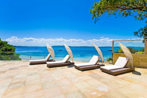 尼尔森湾阿玛纳豪华海滩度假酒店 的俯瞰大海的庭院里摆放着一组椅子