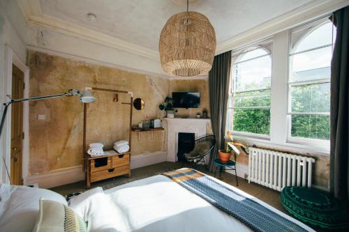 伦敦库尔佩珀酒店的一间卧室配有一张床和一个吊灯