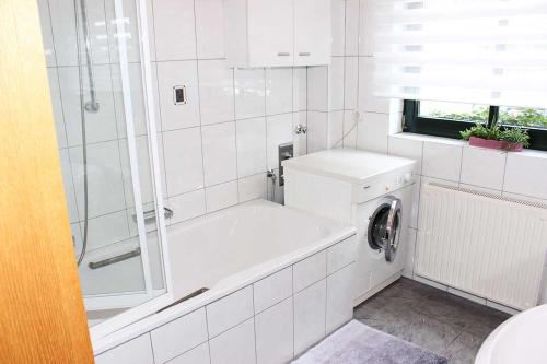 克莱沃Casa Clara的带浴缸和洗衣机的白色浴室