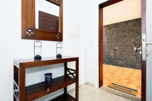 普拉亚布兰卡Lanza Coloradas 20 - PISCINE CHAUFFEE的一间带木桌和镜子的浴室