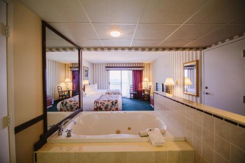 特拉弗斯城海岸度假酒店的酒店客房设有浴缸和卧室。