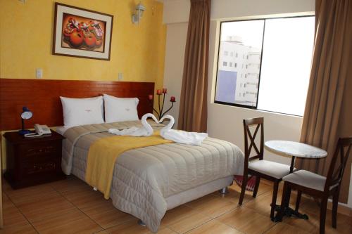 利马艾法罗力托酒店的酒店客房,配有一张天鹅床