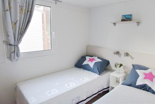 耶泽拉Mobile Homes Murter的一间卧室设有两张床和窗户。