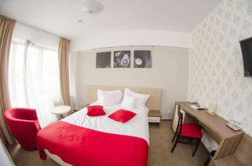 图尔达Potaissa Hotel的酒店客房配有红色的床和书桌