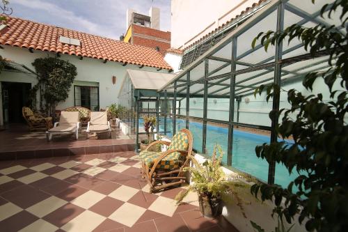 苏克雷Casa Verde B&B的一座带椅子的庭院和一座位于大楼内的游泳池