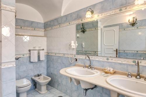 卡普里里贾纳克里斯蒂娜酒店的浴室设有2个水槽、卫生间和镜子。