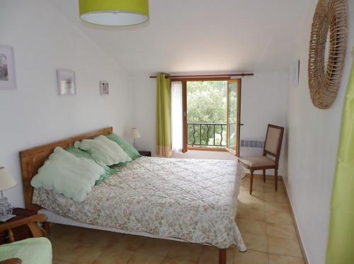PontevèsVacances en Provence的一间卧室设有一张床、一个窗口和一把椅子