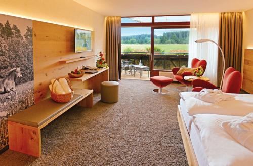 弗罗伊登施塔特格鲁纳森林酒店的酒店客房,配有一张床、一张桌子和椅子