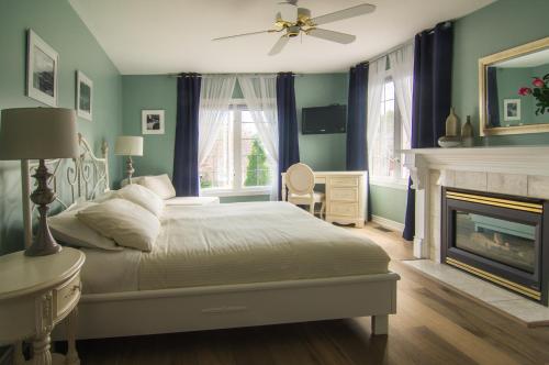 滨湖尼亚加拉优雅酒店的卧室配有白色的床和壁炉