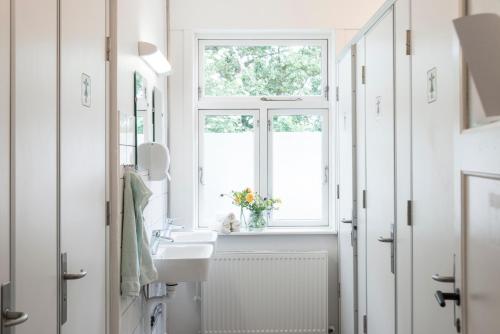 海斯勒Nordliv Strand的白色的浴室设有水槽和窗户。