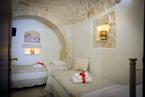洛科罗通多Trullo Di Tagaro的一间卧室设有一张床和石墙