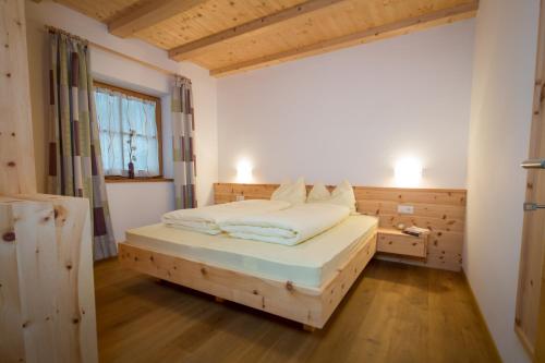 韦尔图尔诺Brugger Hof的一间卧室设有一张木床和一个窗户。