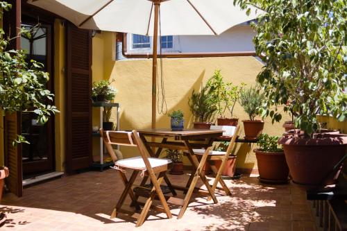 夸尔图丘Pimpioxelli的庭院配有桌椅和遮阳伞。