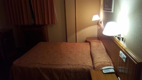 莫蒂利亚德尔帕兰卡尔Hotel del Sol的一张小床,位于酒店客房内,配有时钟