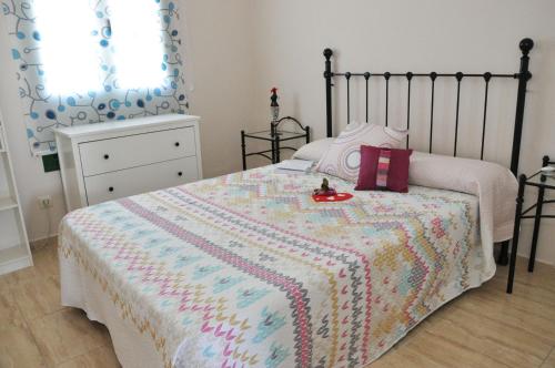 卡门港Apartamentos Dunia 211的一间卧室配有一张带毯子和梳妆台的床