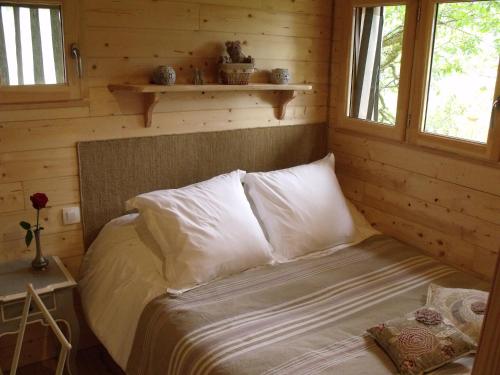 SusmiouLa Cabane du Vieux Chêne的小木屋内一间卧室,配有一张床